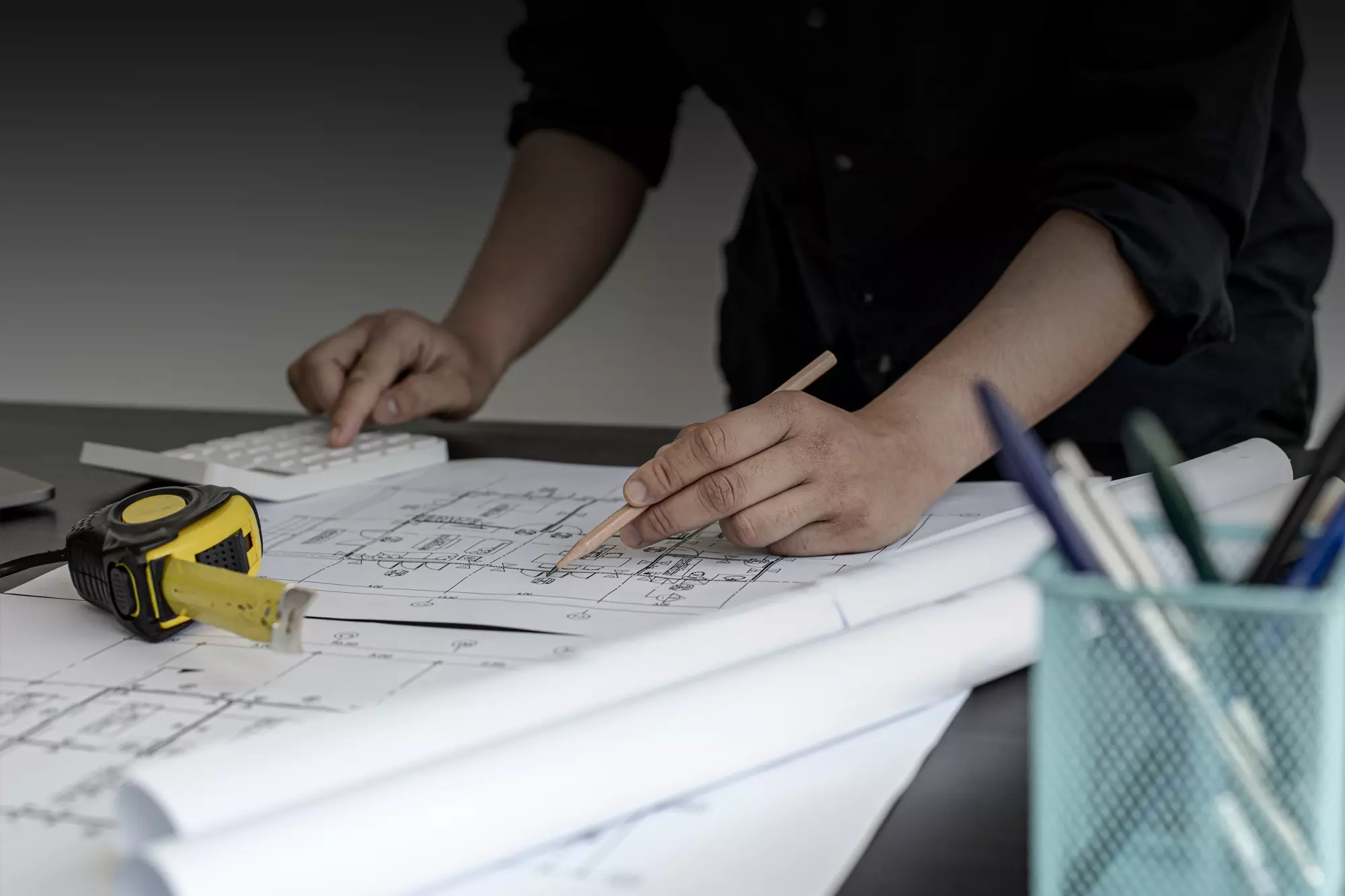 using pencil and calculating on blueprint