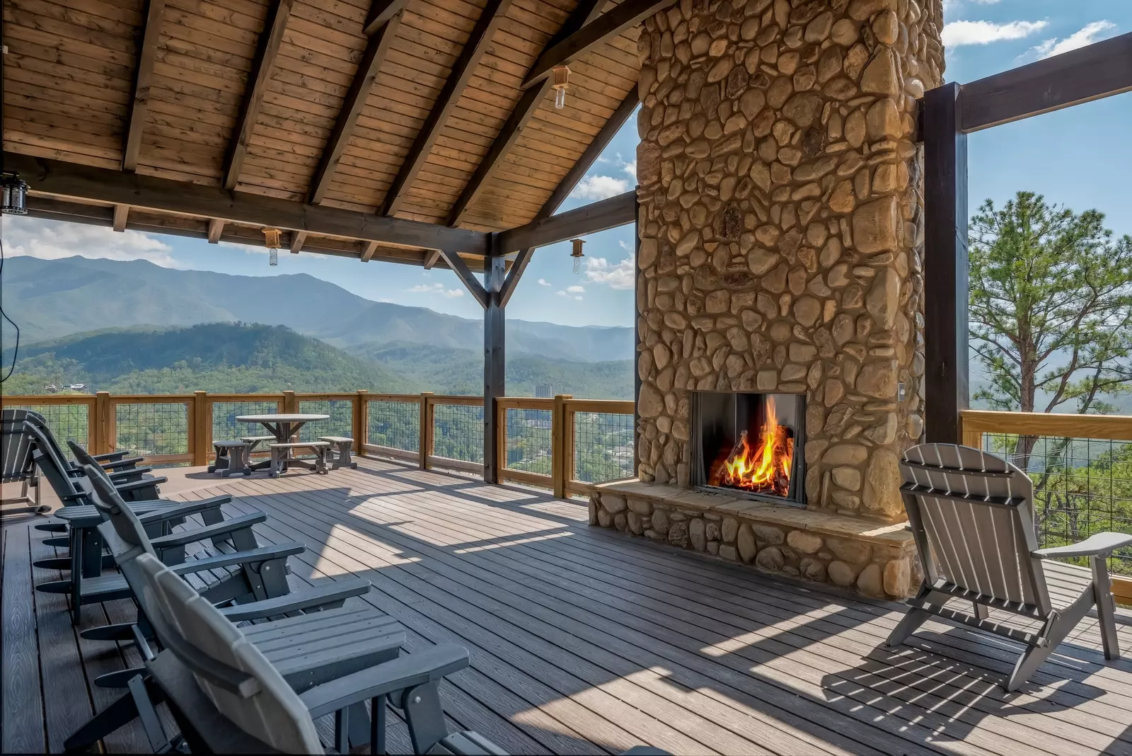 outdoor fireplace on deck with mountain view